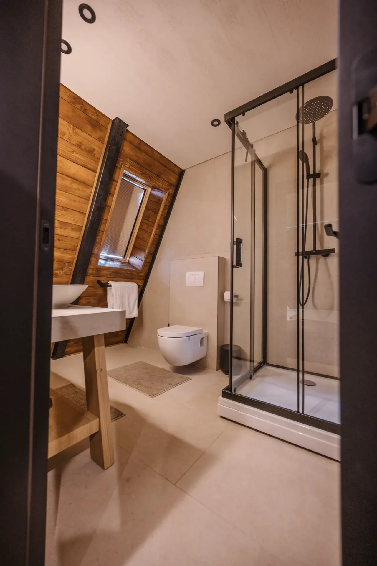 Timber-clad bathroom with a stone basin on a timber frame and a glass walk-in shower