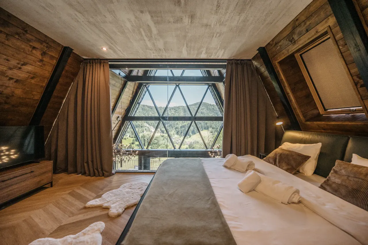 Master bedroom facing the panoramic triangular glass gable and the hills beyond