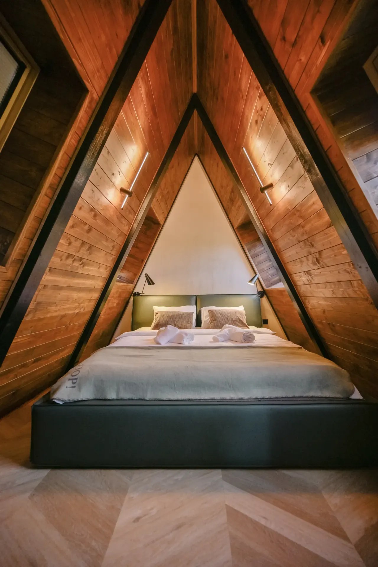 Attic bedroom nestled symmetrically under the timber A-frame ridge
