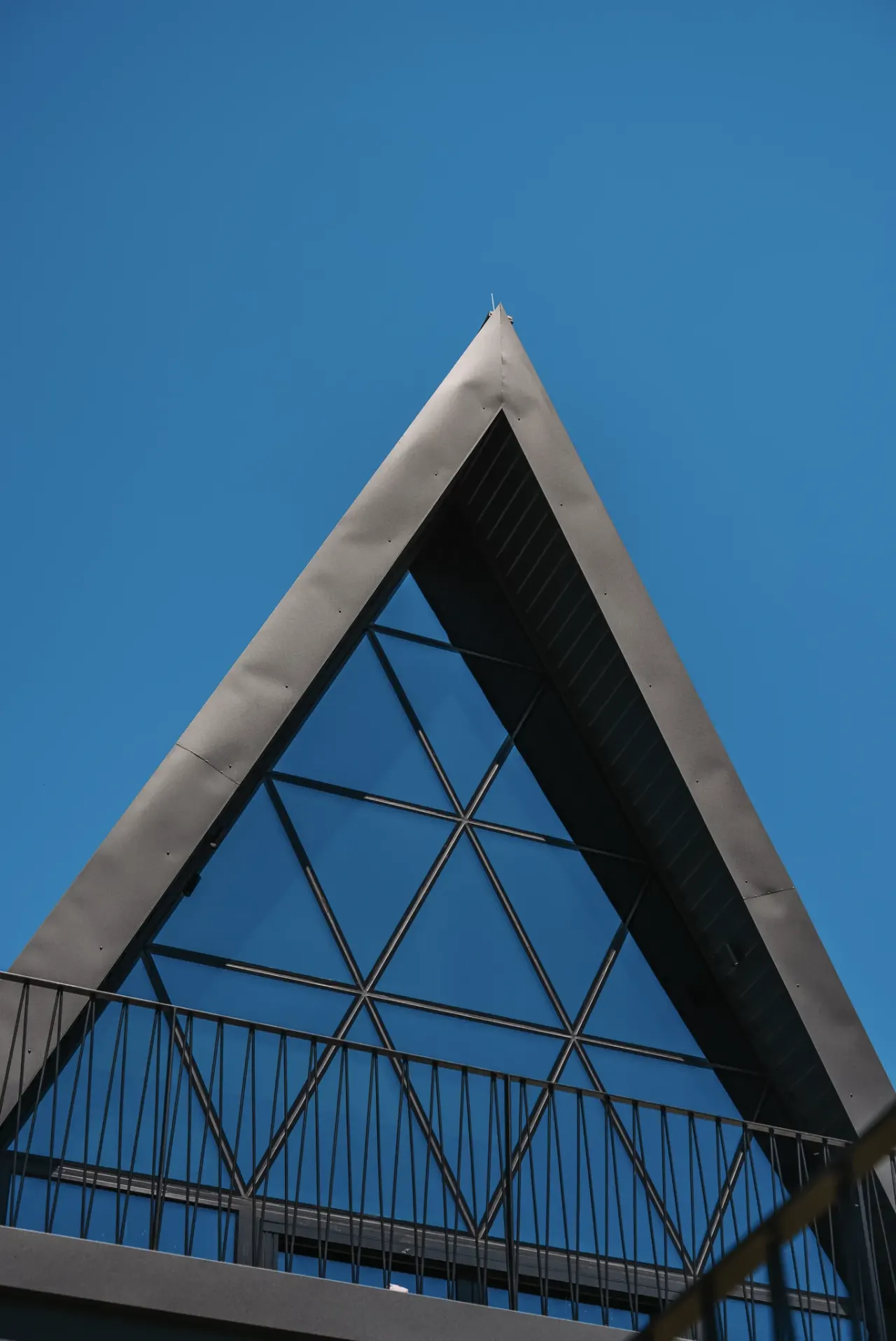 The A-frame's glazed apex rising against the summer sky