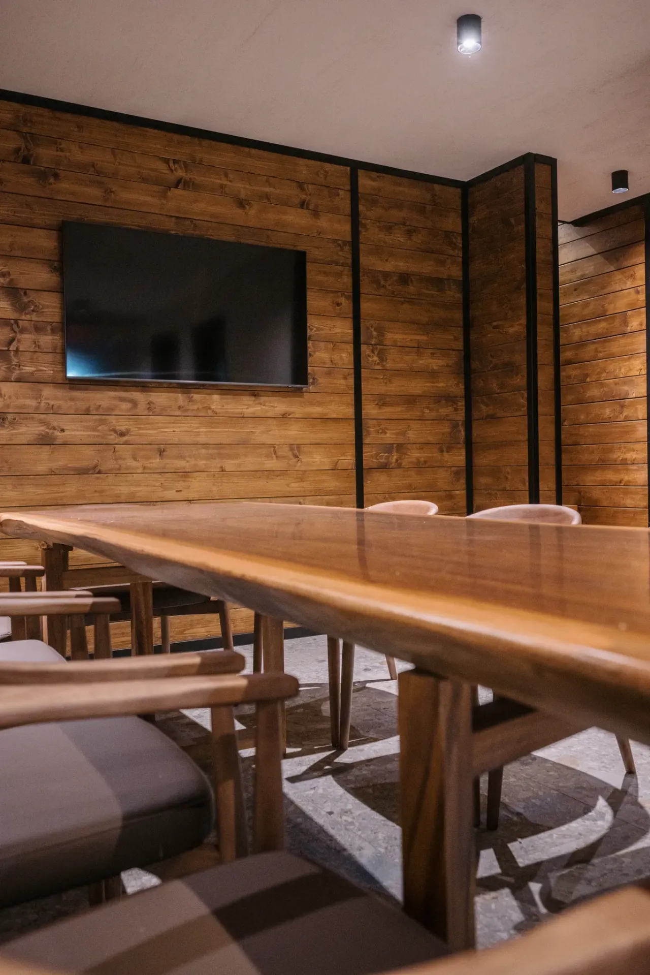 Solid timber table and chairs in the konoba, screen mounted on the timber wall