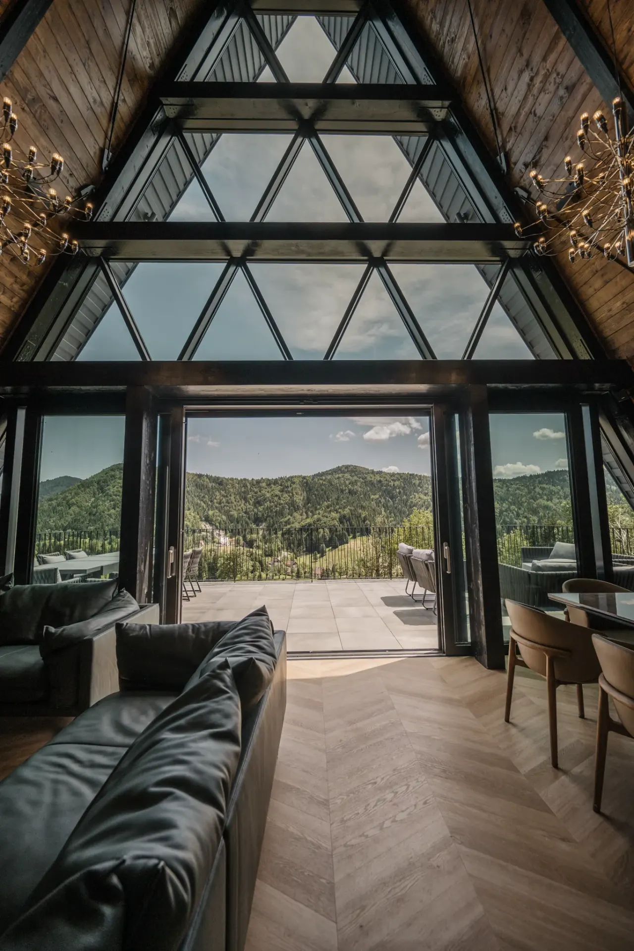 The 13-metre glass wall folded open to the terrace, chandeliers overhead