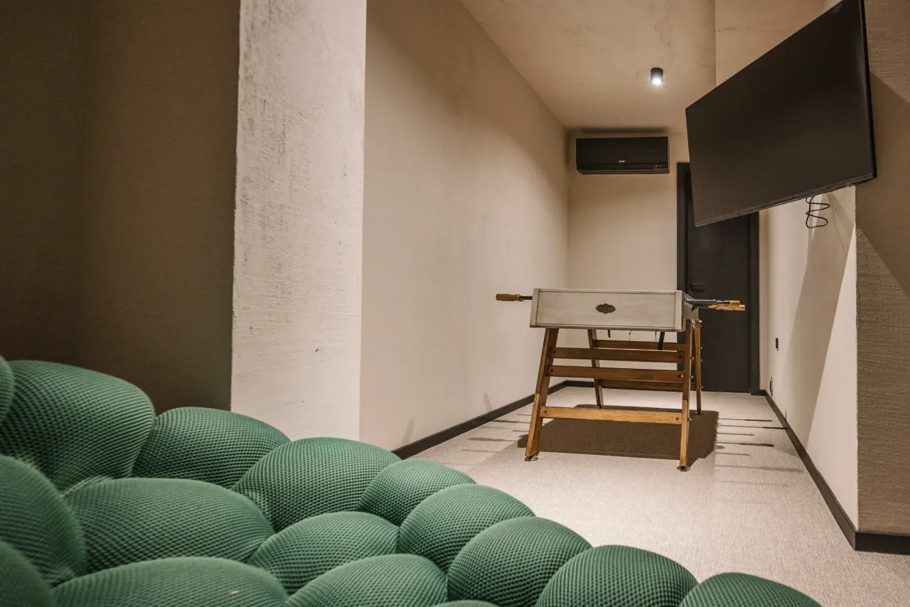 The play room with its long bench seat, foosball table and wall-mounted screen