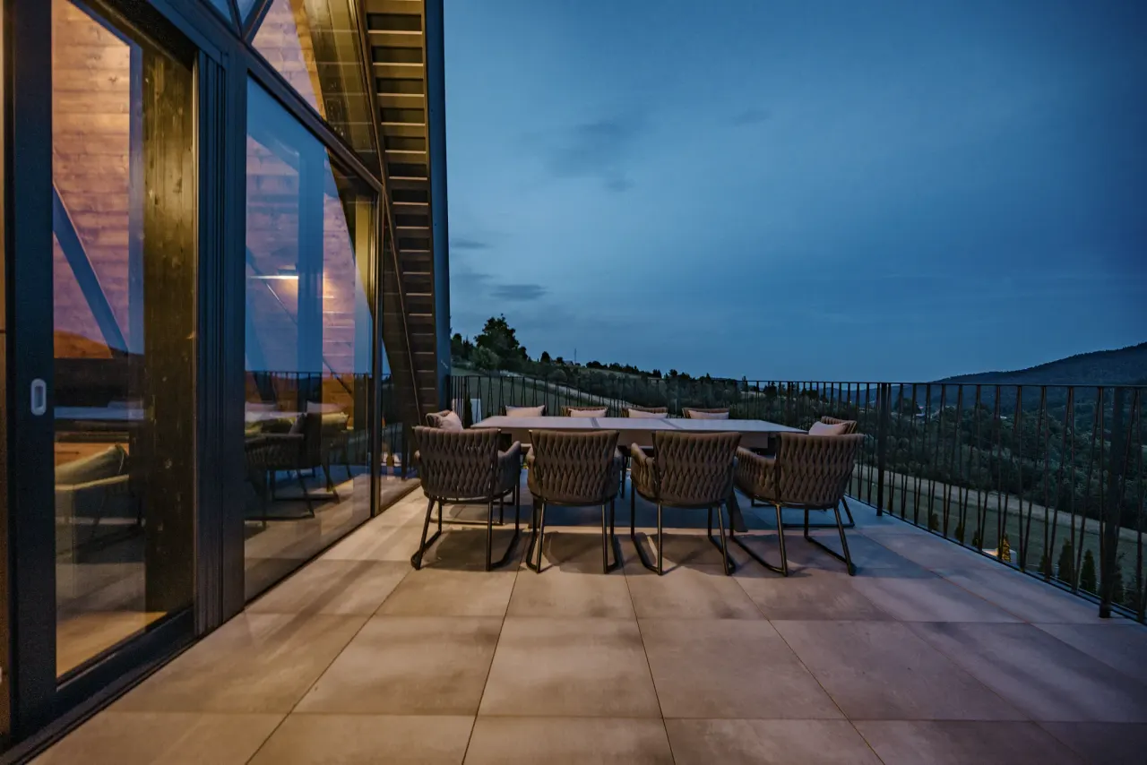 Terrace dining set at blue hour with the valley beyond