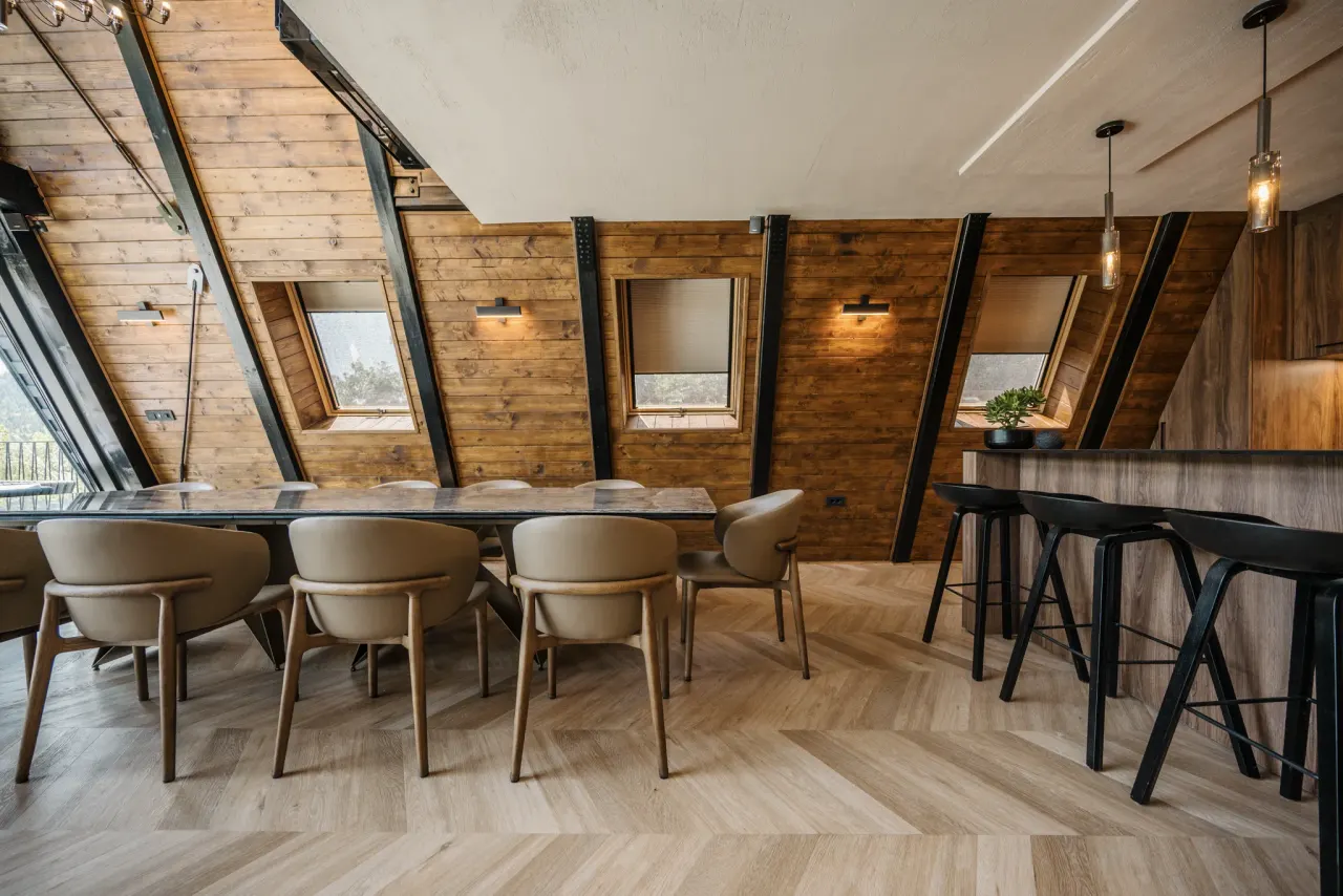 Main dining table set beneath the sloping A-frame ceiling