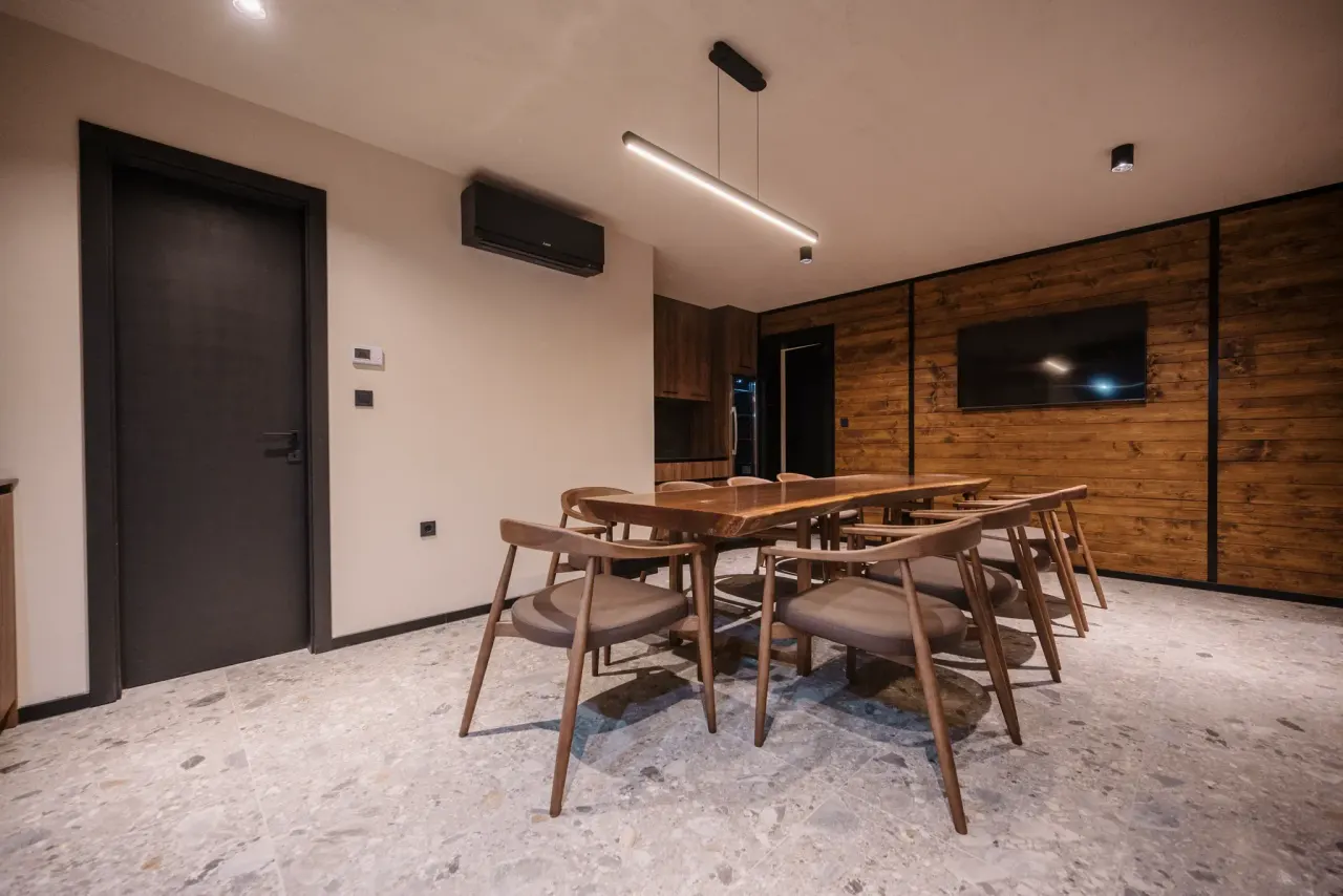 The konoba dining table and chairs on terrazzo, screen mounted on the timber wall